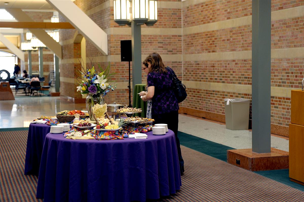 Guests browse food at a reception in the atrium of the Beckman Institute.