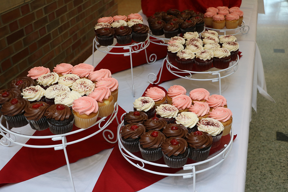 Stands of multicolored cupcakes are displayed on a table in the atrium of the Beckman Institute.