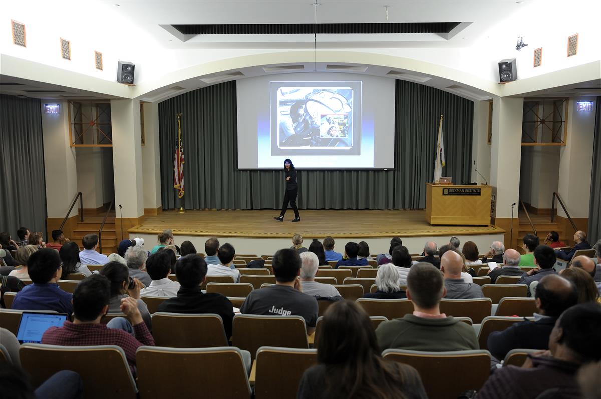 A crowd listens to a speaker in the Beckman Auditorium