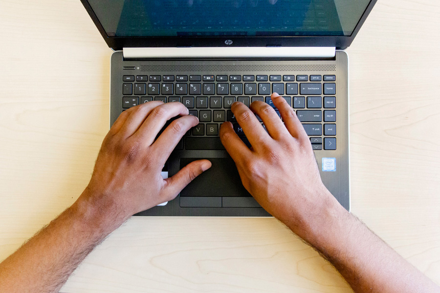 aerial view of a laptop with a person's hands poised on the keyboard