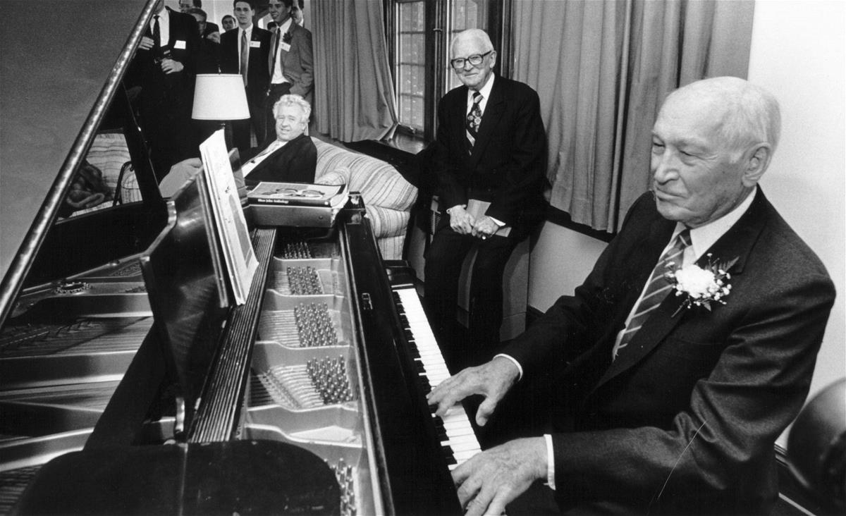 Arnold Beckman plays piano at the Delta Upsilon house on April 6, 1989. His college friend, Seely Johnston, looks on. The event was a part of the inauguration of the Beckman Institute