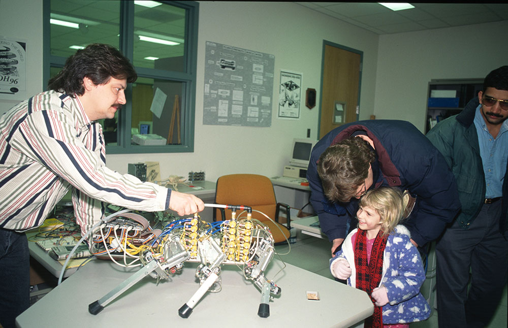 John Hart demonstrates a cockroach robot Beckman's first Open House in 1997.