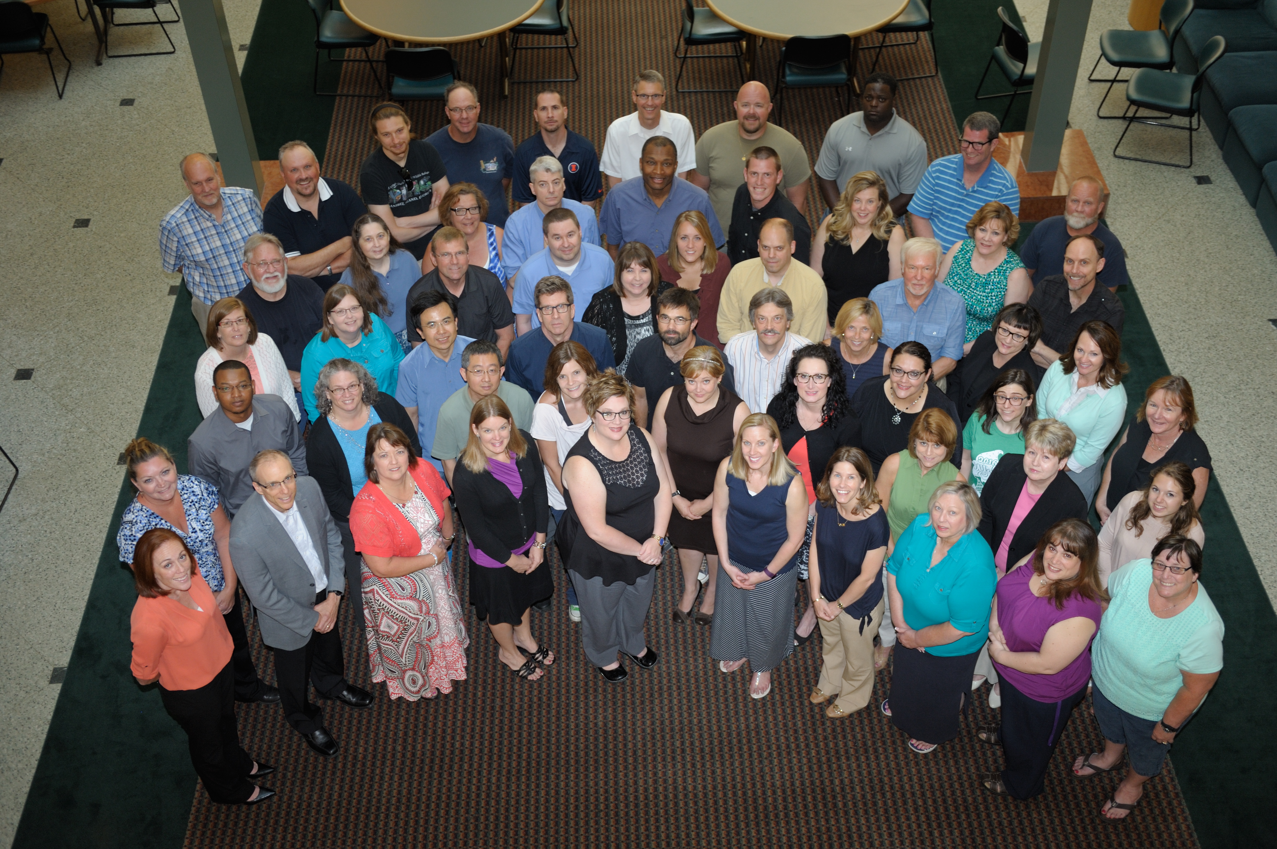 A view of Beckman staff members standing in the atrium, as taken from a bridge, at the Beckman Institute at the University of Illinois at Urbana-Champaign (UIUC)