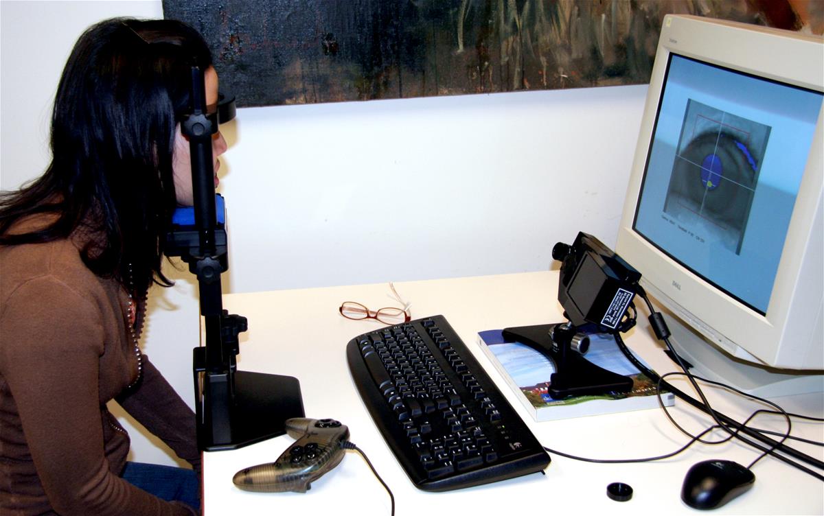 An eye tracker measures a research subject's eyes at the Beckman Institute, while an image of the eyes shows up on the computer monitor opposite.