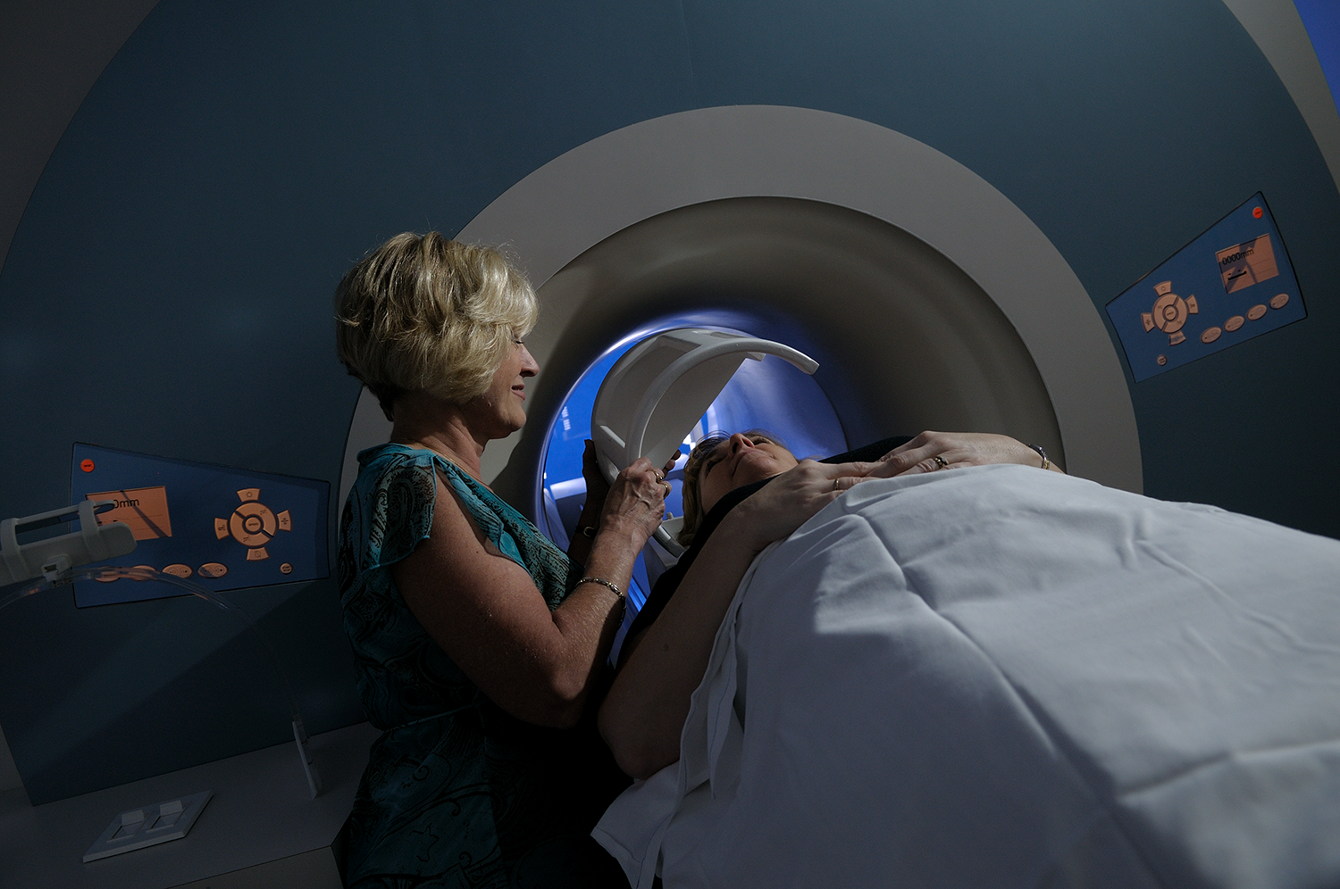 An MRI tech stands over a research subject in Beckman's Biomedical Imaging Center